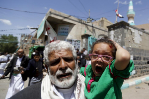 A man carries an injured child to safety during Friday's bombings. Photo: Reuters/Khaled Abdullah <br/>