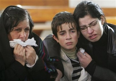 Palestinian Christian relatives of Wassem Saba, 22, who was killed in an Israeli missile strike, react during his funeral at Deir Al-Latin Church in Gaza City, Wednesday, Jan. 7, 2009. Israel said Wednesday that it 'welcomes' an Egyptian-French ceasefire proposal for Gaza as long as such a deal guarantees a halt to militant rockets and weapons smuggling, in a possible sign that a bloody 12-day offensive could be winding down. <br/>Photo: AP Images / Adel Hana