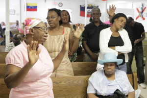 Church members pray at the the Independent Haitian Assembly of God church in Fort Pierce, Fla. Eight people were killed and 10 injured when a van from their church crashed early Monday. AP <br/>