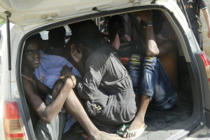 Students take cover in a vehicle after fleeing an attack by Islamic gunmen at Garissa University College. Photo: AP <br/>