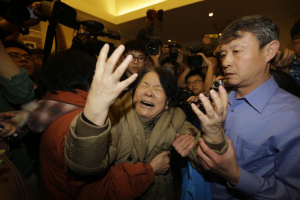 A family member of a passenger aboard Malaysia Airlines MH370 cries as she is surrounded by journalists after watching a television broadcast of a news conference, at the Lido hotel in Beijing, March 24, 2014.  <br/>Reuters