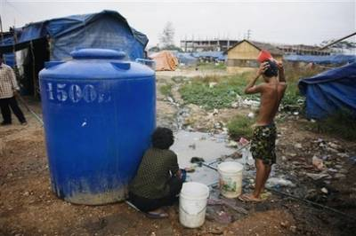 A Cambodian bathes near his slum home Thursday, Feb. 19, 2009, on the outskirts of Phnom Penh, Cambodia. According to government sources an estimated 35 percent of Cambodians live under the poverty line. <br/>(Photo: AP Images / David Longstreath)
