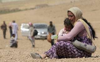 A displaced woman and child flee violence from ISIS in Sinjar, Iraq. <br/>CNS Photo