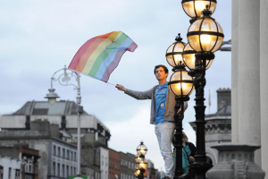 A man waves the rainbow colored flag as he celebrates a landslide victory of a Yes vote after a referendum on same sex marriage was won by popular ballot vote by a margin of around two-to-one at Dublin Castle. Image by: Clodagh Kilcoyne / Getty Images <br/>