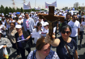 A Christian woman carries a cross during a demonstration against militants of the Islamic State, formerly known as the Islamic State in Iraq and the Levant (ISIL), in Arbil, north of Baghdad July 24, 2014. Hundreds of Iraqi Christians marched to the United Nations office in Arbil city on Thursday calling for help for families who fled in the face of threats by Islamic State militants. Photo: REUTERS / STRINGER <br/>