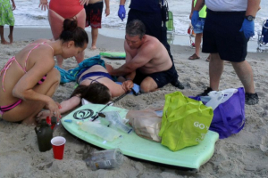 People assist a teenage girl at the scene of a shark attack in Oak Island, N.C., Sunday, June 14, 2015.  <br/>Steve Bouser/The Pilot, Southern Pines, N.C. via AP
