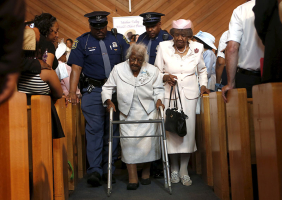Jeralean Talley, the world's oldest-known living person, is escorted down the aisle following a church service and celebration for her 116th birthday in Inkster, Michigan May 24, 2015. REUTERS/Rebecca Cook  <br/>