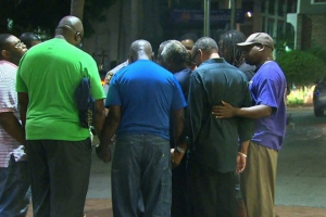 A small prayer circle forms nearby where police are responding to a shooting at the Emanuel AME Church in Charleston, South Carolina June 17, 2015. <br/>Getty Images