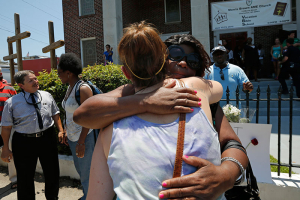 Mourners embrace outside Morris Brown AME Church before attending a vigil the day after a mass shooting in Charleston, South Carolina June 18, 2015. A 21-year-old white gunman accused of killing nine people at a historic African-American church in Charleston, South Carolina, was arrested on Thursday, said U.S. officials, who are investigating the attack as a hate crime. REUTERS/Brian Snyder <br/>