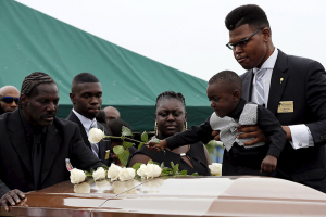 A boy places a white rose on the casket of Ethel Lance as she is buried at the Emanuel African Methodist Episcopal Church cemetery in North Charleston, South Carolina June 25, 2015. Lance is one of the nine victims of the mass shooting at the Emanuel African Methodist Episcopal Church. REUTERS/Brian Snyder <br/>