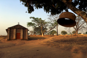 A church bell hangs from a tree brunch outside a catholic church and a school in Odek village, north of Uganda capital Kampala, February 14, 2015. (PHOTO: REUTERS/JAMES AKENA) <br/>