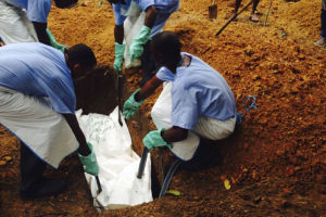 Volunteers lower a corpse, which is prepared with safe burial practices to ensure it does not pose a health risk to others and stop the chain of person-to-person transmission of Ebola, into a grave in Kailahun July 18, 2014.  <br/>Reuters/Tarik Jasarevic