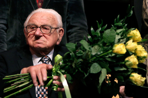 Nicholas Winton holds flowers while sitting on a stage after the premiere of the movie 