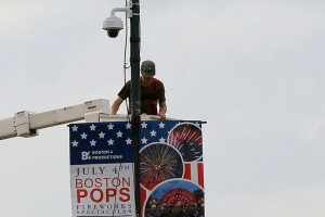 A worker installs a piece of security equipment on a lamp post on a bridge over the Charles River in Boston, Massachusetts July 2, 2013, in preparations for the city's Fourth of July celebrations. Security officials said they would deploy record numbers of police and install scores of new surveillance cameras and checkpoints around fireworks displays, concerts and other Fourth of July events in Boston, New York, Washington and Atlanta. REUTERS/Brian Snyder <br/>