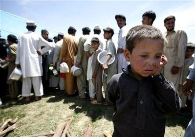 Children wait to get food at a refugee camp in Mardan, in northwest Pakistan, Monday, May 11, 2009. The U.N. said 360,600 refugees had fled Swat and neighboring Dir and Buner districts since Pakistan's army launched a new offensive against Taliban militants last week. <br/>(Photo: AP / Greg Baker)
