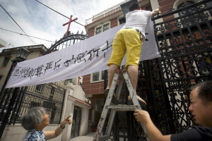 In this July 30, 2015 photo, church members put up a banner reading 