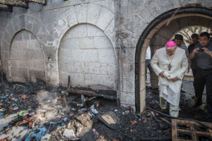 A priest inspects the damage caused to the Church of the Multiplication at Tabgha, on the Sea of Galilee, in northern Israel, which was set on fire in July.  <br/>AFP Photo