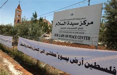 A sign with Arabic writing 'Palestine the land of Jesus is eager for justice, peace and stability' is seen at the Lady of Peace church, background, the first scheduled stop for Pope Benedict XVI's visit to the region, in Amman, Jordan Thursday, May 7, 2009. Pope Benedict XVI began a week long tour in the Middle East on Friday that includes Jordan and Israel, a self-described 'pilgrim of peace' seeking to strengthen frayed ties with Muslims and Jews and give support to his beleaguered Christian flock in the region. <br/>(Photo: AP / Nasser Nasser)
