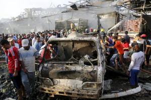 Residents gather at the site of a truck bomb attack at a crowded market in Baghdad in April 2015. <br/>Reuters