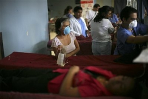 A woman wearing a face mask, as a precaution to swine flu, waits for a doctor at the emergency room of the San Juan de Dios hospital in Guatemala City, Wednesday, June 10, 2009. The World Health Organization is gearing up to declare a swine flu pandemic, a move that could trigger both the large-scale production of vaccines and questions about why the step was delayed for weeks as the virus continued to spread. <br/>(Photo: AP Images / Rodrigo Abd)