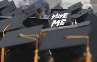 A cap worn by graduate Paul Szeto, of Cambridge, Mass., reads, 'hire me' as graduates listens to speakers during University of Massachusetts -Boston commencement, Friday, May 29, 2009 in Boston. Job prospects for college graduates are not promising in this time of financial turmoil. <br/>(Photo: AP Images / Lisa Poole)