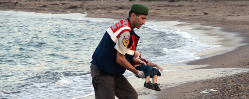A Turkish paramilitary police officer carries the body of 3-year-old Aylan Kurdi. <br/>AP photo