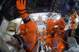 Spacesuit engineers demonstrate how four crew members would be arranged for launch inside the Orion spacecraft, using a mockup of the vehicle at Johnson Space Center.<br />
 <br/>NASA/Robert Markowitz