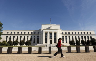 A woman walks past the Federal Reserve headquarters in Washington September 16, 2015. REUTERS/Kevin Lamarque <br/>