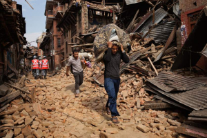 A Nepalese man carries recovered belongings through the streets of Bhaktapur in the Kathmandu Valley, <br/>Reuters