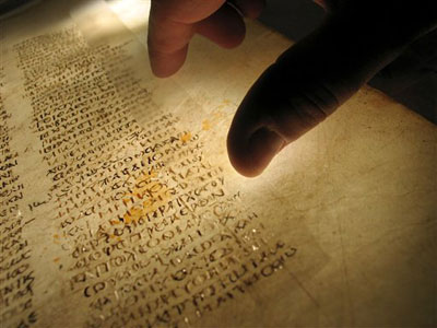 This undated picture made available by the British Library shows a reader examining a page from the earliest surviving Christian Bible. The British Library says the surviving pages of the world's oldest Bible have been reunited - digitally. The library says the early Christian work known as the Codex Sinaiticus had been housed in four separate locations across the world for more than 150 years. It became available Monday for perusal on the Web so scholars and others can get a closer look <br/>(Photo: AP / The British Library)