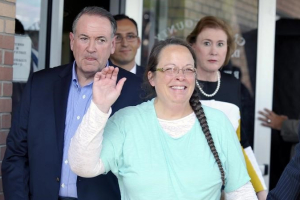 Kim Davis, flanked by Republic presidential candidate Mike Huckabee (L) waves as she walks out of jail in Grayson, Kentucky September 8, 2015. REUTERS/Chris Tilley <br/>