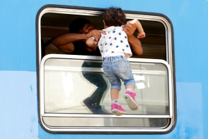 A migrant carries a child in a train at the station in Beli Manastir, Croatia September 18, 2015. REUTERS/Laszlo Balogh <br/>