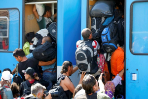 Migrants scramble aboard a train at the station in Beli Manastir, Croatia September 18, 2015. REUTERS/Laszlo Balogh <br/>