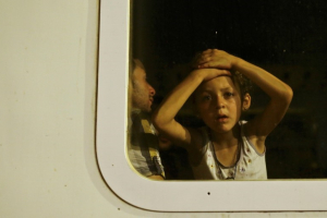 A migrant child looks out of a train window at a train station in Tovarnik, September 19, 2015. REUTERS/Antonio Bronic <br/>
