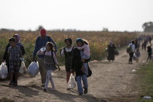 Migrants walk on a dirt road close to the Croatian border near the town of Sid, Serbia, September 19, 2015. REUTERS/Stoyan Nenov <br/>