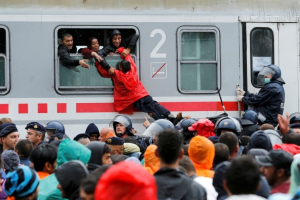 Migrants pull a boy through a train window at the station in Tovarnik, Croatia, September 20, 2015. REUTERS/Antonio Bronic <br/>