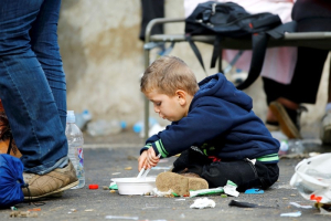 A migrant boy eats on the ground at the check point Heiligenkreuz, Austria, September 20, 2015, located at the border with Hungary. Hungary and Croatia traded threats on Saturday as thousands of exhausted migrants poured over their borders, deepening the disarray in Europe over how to handle the tide of humanity. REUTERS/Leonhard Foeger <br/>