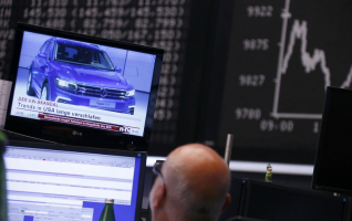 A Volkswagen Tiguan car appears in a news broadcast on a TV in front of the German share price index DAX board, at the stock exchange in Frankfurt, Germany September 21, 2015. REUTERS/Ralph Orlowski <br/>