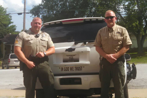 Stone County Sheriff Doug Rader, left, displaying bumper stickers placed on his department’s patrol cars.  <br/>Stone County Sheriff’s Office