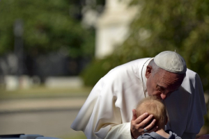 Pope Francis kisses a baby as he parades around the White House Ellipse in Washington September 23, 2015. REUTERS/James Lawler Duggan <br/>
