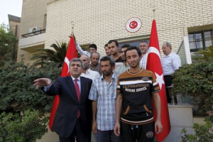 Faruk Kaymakci, the Turkish ambassador to Iraq (L) and Turkish workers stand in front of the Turkish embassy in Baghdad, Iraq, September 30, 2015.  <br/>REUTERS/Ahmed Saad