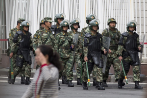 Paramilitary policemen with shields and batons patrol near People's Square in Urumqi, China's northwestern region <br/>South China Morning Post