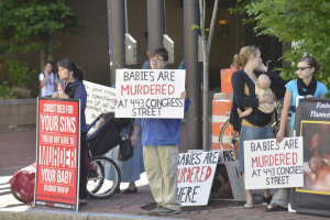 Anti-abortion activists stand across Congress Street from the Planned Parenthood of New England's clinic. <br/>AP photo