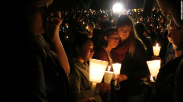 People gather for a candlelight vigil held in honor of those killed during a mass shooting at Umpqua Community College in Oregon on Thursday. <br/>AP photo