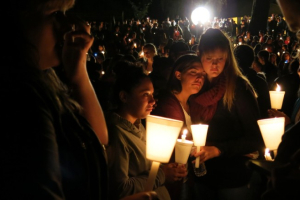 People gather for a candlelight vigil held in honor of those killed during a mass shooting at Umpqua Community College in Oregon on Thursday. <br/>AP photo