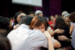 Married couples giving hugs to their spouses. <br/>(HKHolyMarriage.org)