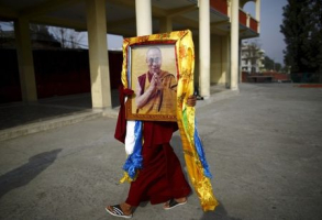 A Tibetan monk carries a portrait of exiled Tibetan spiritual leader, the Dalai Lama, during a function organised to mark 