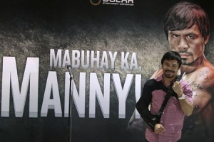 Boxer Manny Pacquiao poses for the members of the media upon his arrival at the international airport in Manila May 13, 2015.  <br/>REUTERS/Romeo Ranoco