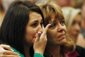 Lacey Scroggins, left, is comforted by her mother Lisa Scroggins during a church service at the New Beginnings Church of God on Sunday in Roseburg, Ore <br/>AP photo