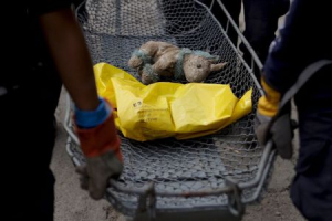 Rescue team members carry a stuffed unicorn and the remains of a mudslide victim towards a temporary morgue, in Santa Catarina Pinula, on the outskirts of Guatemala City, October 5, 2015.  <br/>REUTERS/Josue Decavele